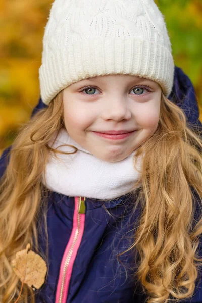 Portrait of a beautiful girl in a blue coat outdoors in autumn — Stock Photo, Image