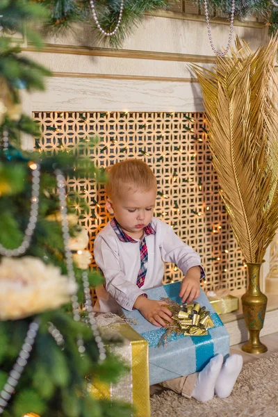 Счастливый мальчик, сидящий у камина в ожидании нового года — стоковое фото