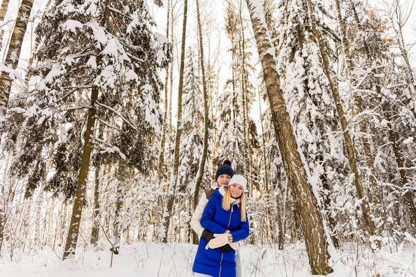 The guy and the girl have a rest in the winter woods. — Stock Photo, Image