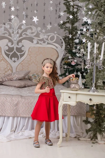 Pequena menina bonita em um vestido de noite vermelho a árvore de Natal . — Fotografia de Stock