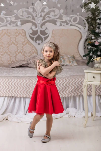 Pequena menina bonita em um vestido de noite vermelho a árvore de Natal . — Fotografia de Stock