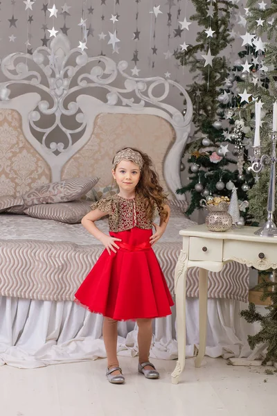 Pequena menina bonita em um vestido de noite vermelho a árvore de Natal . — Fotografia de Stock