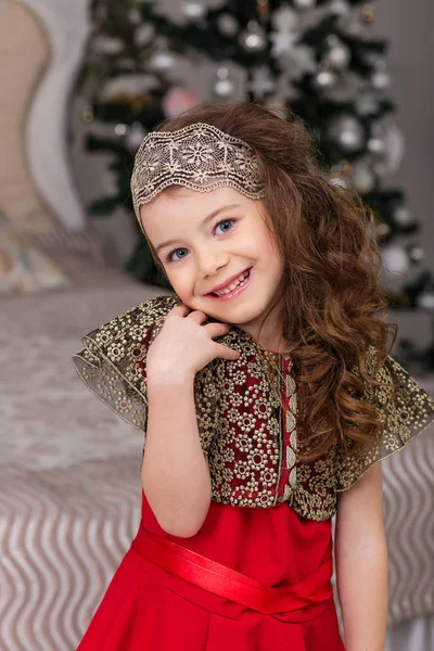 Pequena menina bonita em um vestido de noite vermelho a árvore de Natal . — Fotografia de Stock