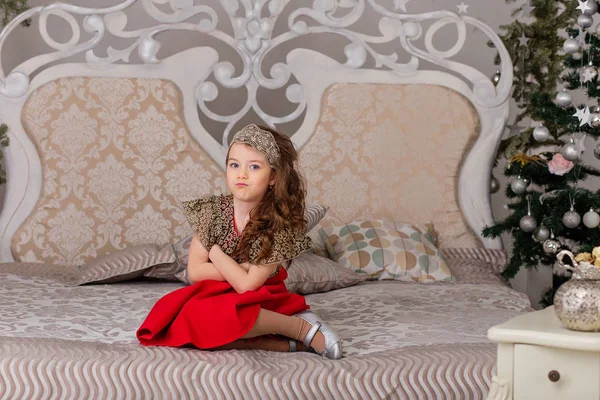 Pequena menina bonita em um vestido de noite vermelho a árvore de Natal . — Fotografia de Stock