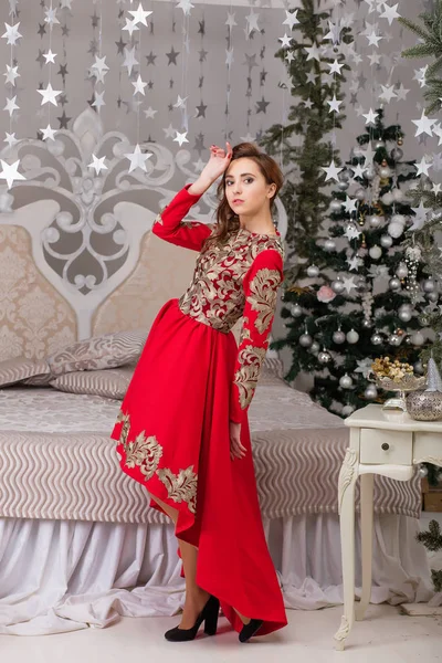 Schönes Mädchen im roten langen Kleid am Weihnachtsbaum — Stockfoto