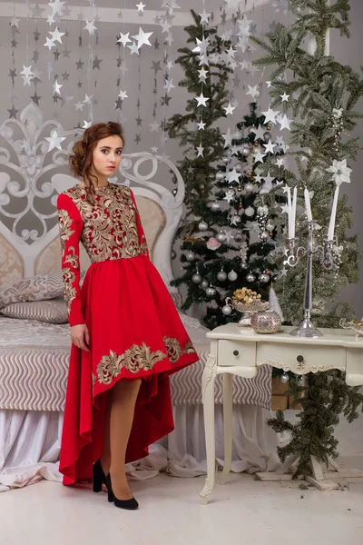 Schönes Mädchen im roten langen Kleid am Weihnachtsbaum — Stockfoto