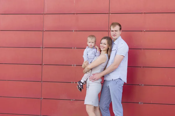 Ritratto di una giovane famiglia su sfondo rosso — Foto Stock