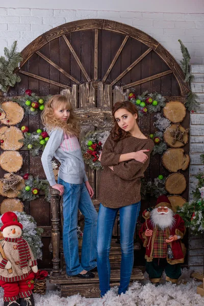 Två vackra flickor poserar i juldekorationer — Stockfoto
