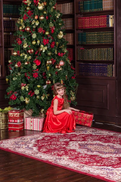 Bella ragazza in un lungo vestito rosso all'albero di Natale . — Foto Stock
