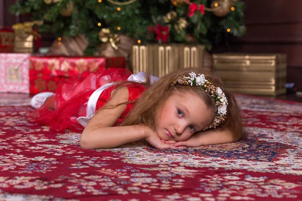 Pequena menina bonita em vestido vermelho na árvore de Natal . — Fotografia de Stock