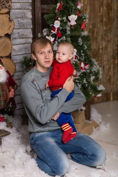Bir Noel ağacın altında oturup çocuk ile genç Baba. 