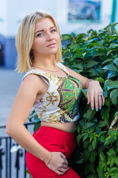 Kırmızı pantolon içinde güzel bir sarışın portresi