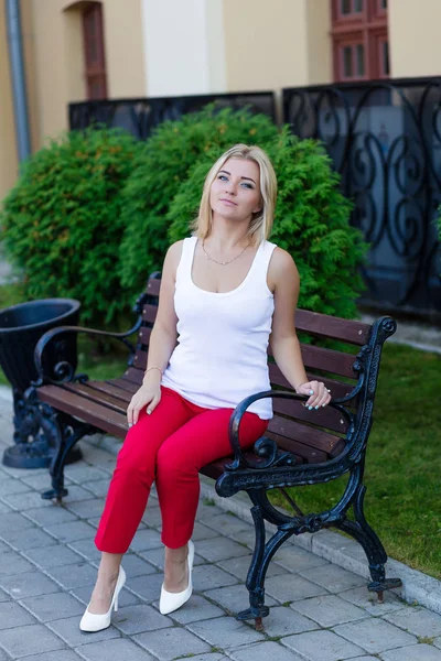 Kırmızı pantolon içinde güzel bir sarışın portresi