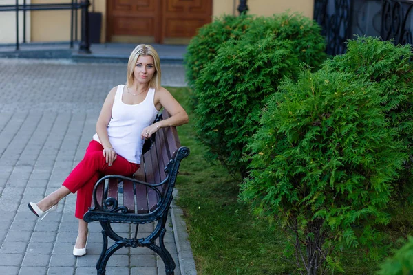 Portrait of a beautiful blonde in red pants — Stock Photo, Image