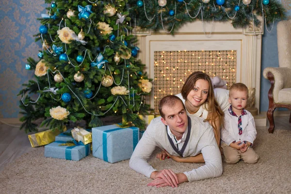 Família feliz sentada ao lado da lareira em antecipação ao novo — Fotografia de Stock