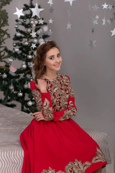 Gyönyörű lány piros hosszú ruha, a karácsonyfa — Stock Fotó