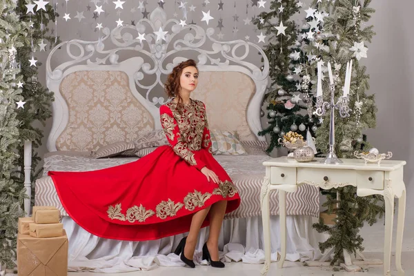 Schönes Mädchen im roten langen Kleid am Weihnachtsbaum — Stockfoto