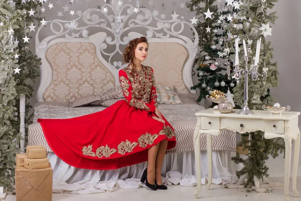 Schönes Mädchen im roten langen Kleid am Weihnachtsbaum — Stockfoto