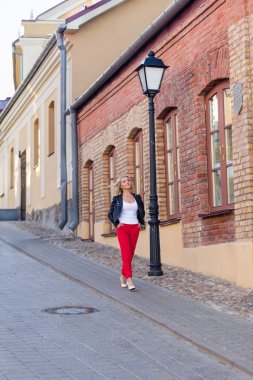 Kırmızı pantolon içinde güzel bir sarışın portresi