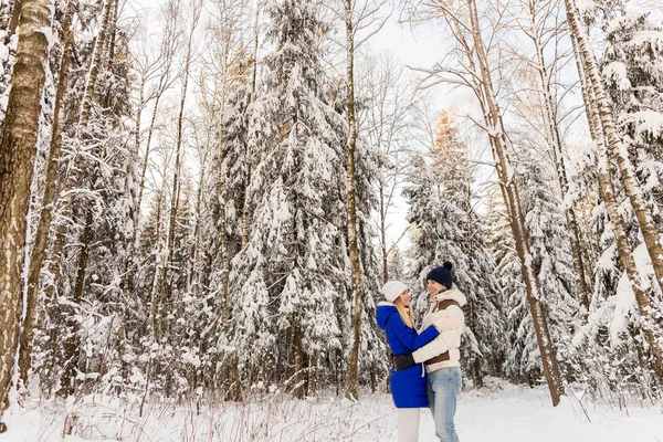 A srác és a lány van a többi a téli erdőben. — Stock Fotó