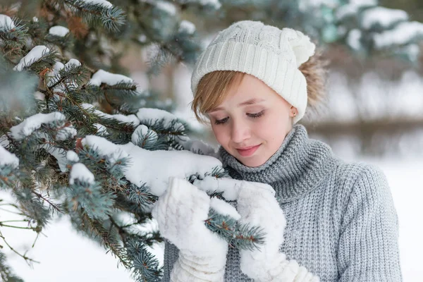 Belle fille dans un chapeau blanc et mitaines en hiver neigeux fo — Photo
