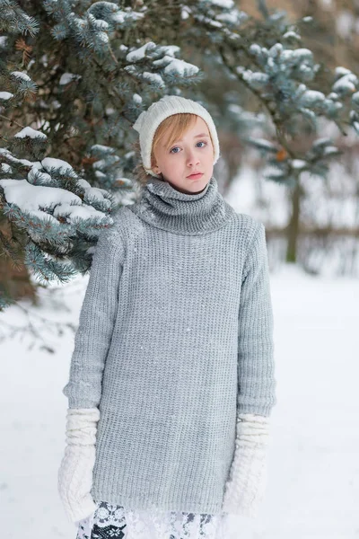 Hermosa chica en un sombrero blanco y manoplas en el invierno nevado fo — Foto de Stock