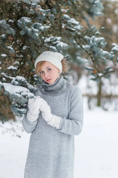 Menina bonita em um chapéu branco e luvas no inverno nevado fo — Fotografia de Stock