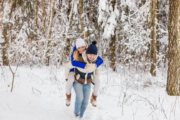 El muchacho y la muchacha descansan en el bosque invernal . — Foto de Stock