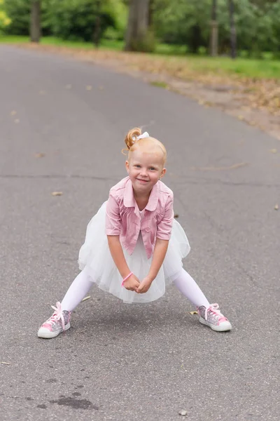 可爱的小女孩，穿着一身漂亮的衣服和运动鞋上玩 — 图库照片