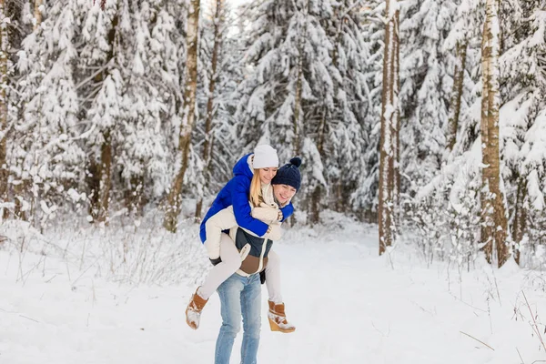 The guy and the girl have a rest in the winter woods. — Stock Photo, Image