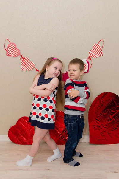 Vackra pojke och flicka på bakgrunden av hjärtan — Stockfoto