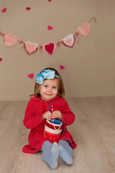 Lilla söta tjejen på väggen i bakgrunden av ett hus — Stockfoto