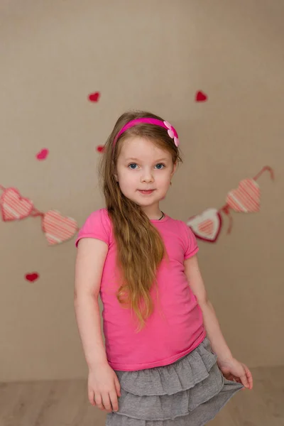 Porträtt av en vacker flicka i en rosa inomhus — Stockfoto
