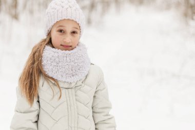 Sevimli kız bir kış ormanda oynarken. 