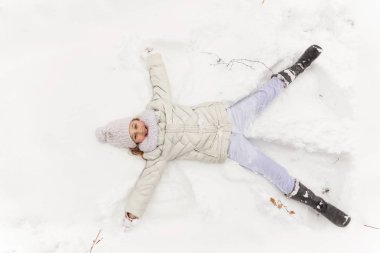 Sevimli kız bir kış ormanda oynarken. 
