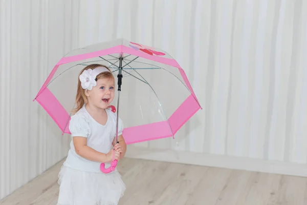 Dulce chica con un paraguas rosa en casa — Foto de Stock