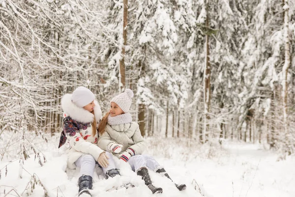 Two girlfriends playing in a winter forest. — Stock Photo, Image