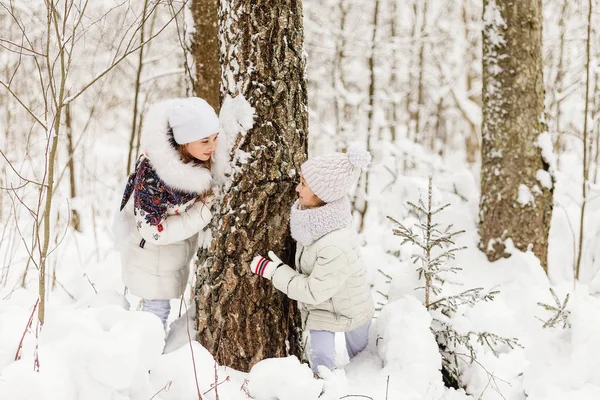 Two girlfriends playing in a winter forest. — Stock Photo, Image