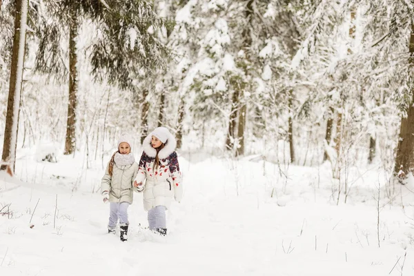 Two girlfriends playing in a winter forest. — Stock Photo, Image