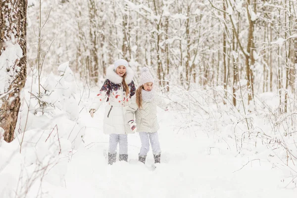 Due amiche che giocano in una foresta invernale . — Foto Stock