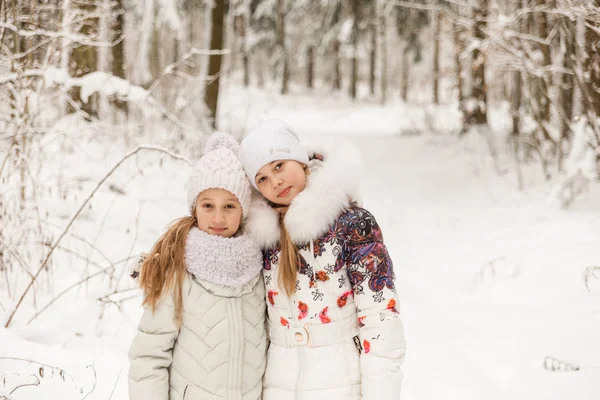 Two girlfriends playing in a winter forest. — Stock Photo, Image