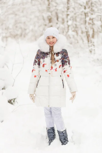 Menina bonito jogar em uma floresta de inverno . — Fotografia de Stock