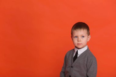 Küçük çocuk Studio kırmızı bir arka plan üzerinde poz. 