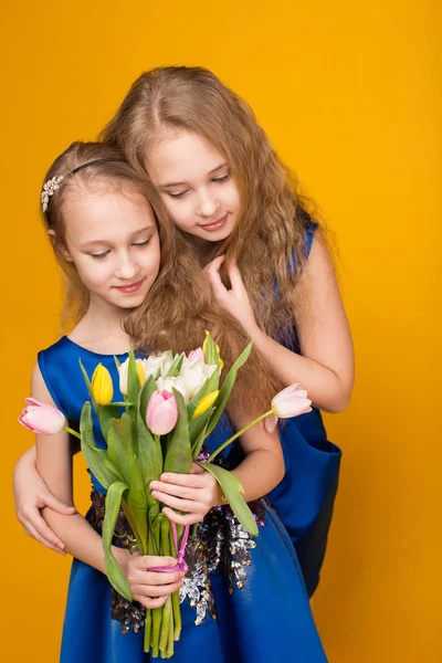 花の花束を持つ 2 つの美しい若い女の子 — ストック写真