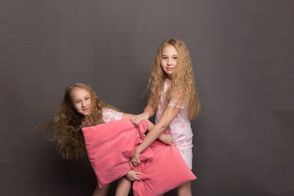 Hermosas dos chicas en pijama rosa juegan antes de irse a la cama — Foto de Stock