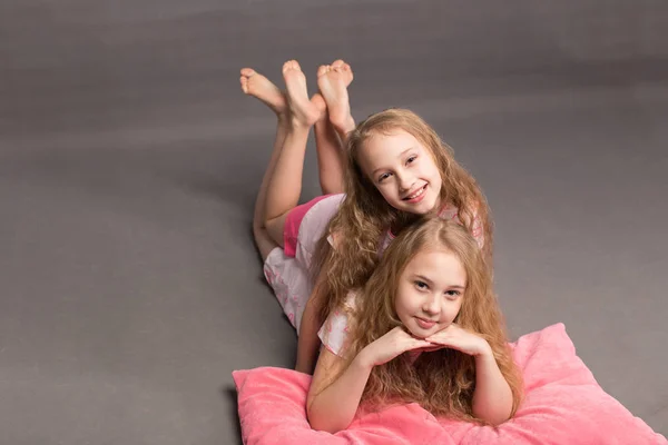 Hermosas dos chicas en pijama rosa juegan antes de irse a la cama — Foto de Stock