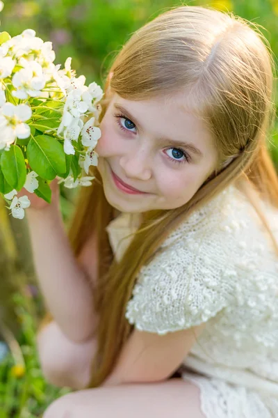 Piękna mała dziewczynka biegnie przez kwitnący ogród w s — Zdjęcie stockowe