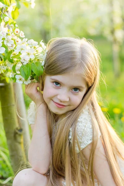 Uma menina bonita corre através de um jardim florido no s — Fotografia de Stock
