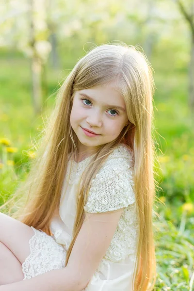 Une belle petite fille court à travers un jardin fleuri dans le s — Photo