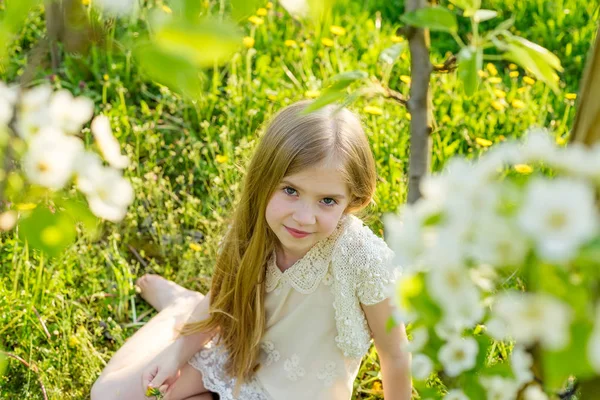 Egy gyönyörű kislány végigfut egy virágzó kert a s — Stock Fotó